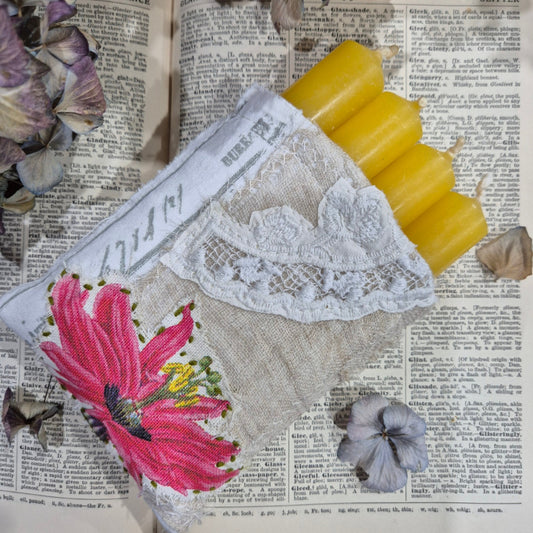 Embroidered fabric with floral design and lace with cancles on a newspaper background
