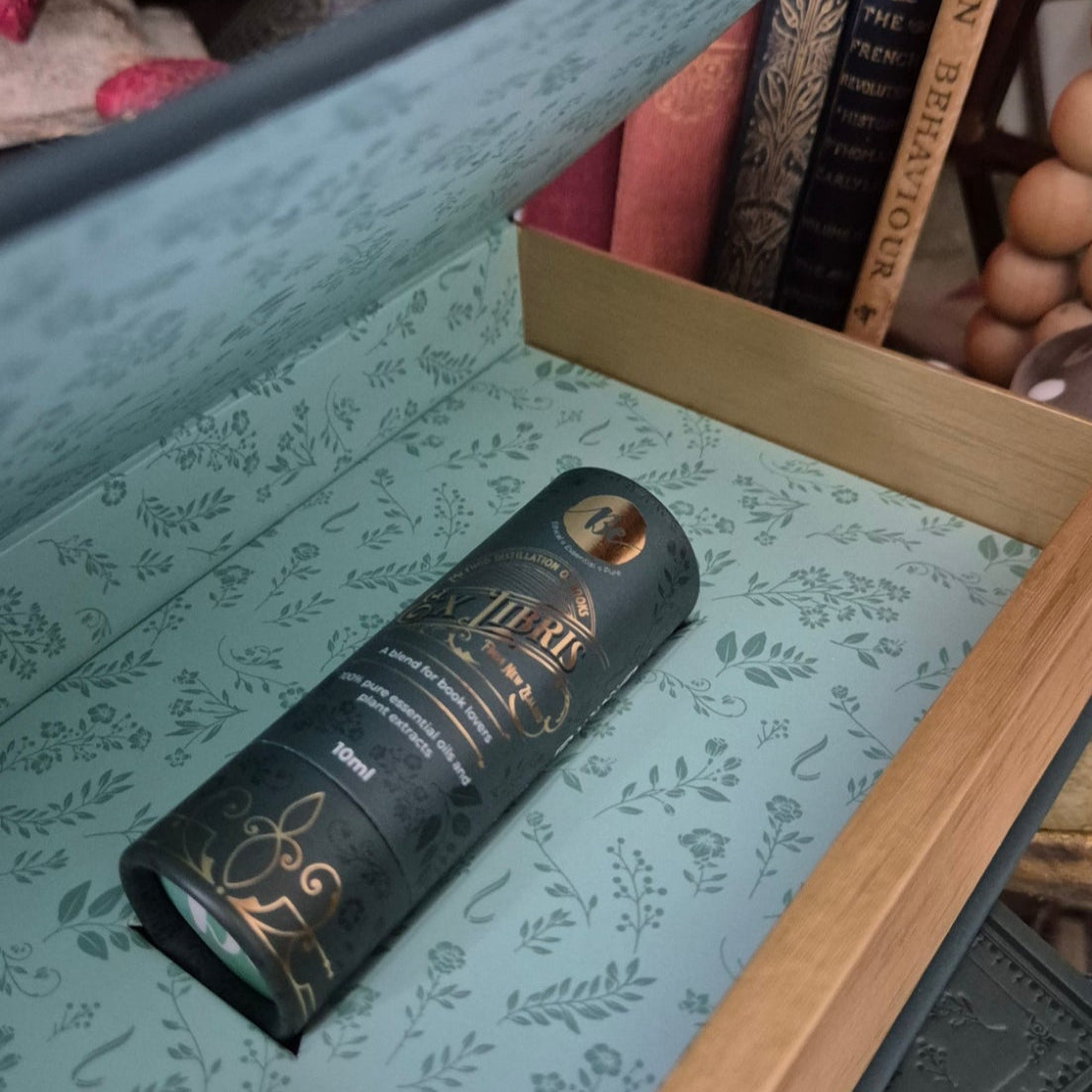 Book with a bottle of oil fragrance inside on a patterned surface