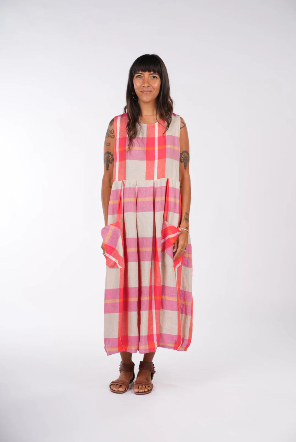 Woman wearing a pink and beige checkered dress on a white background