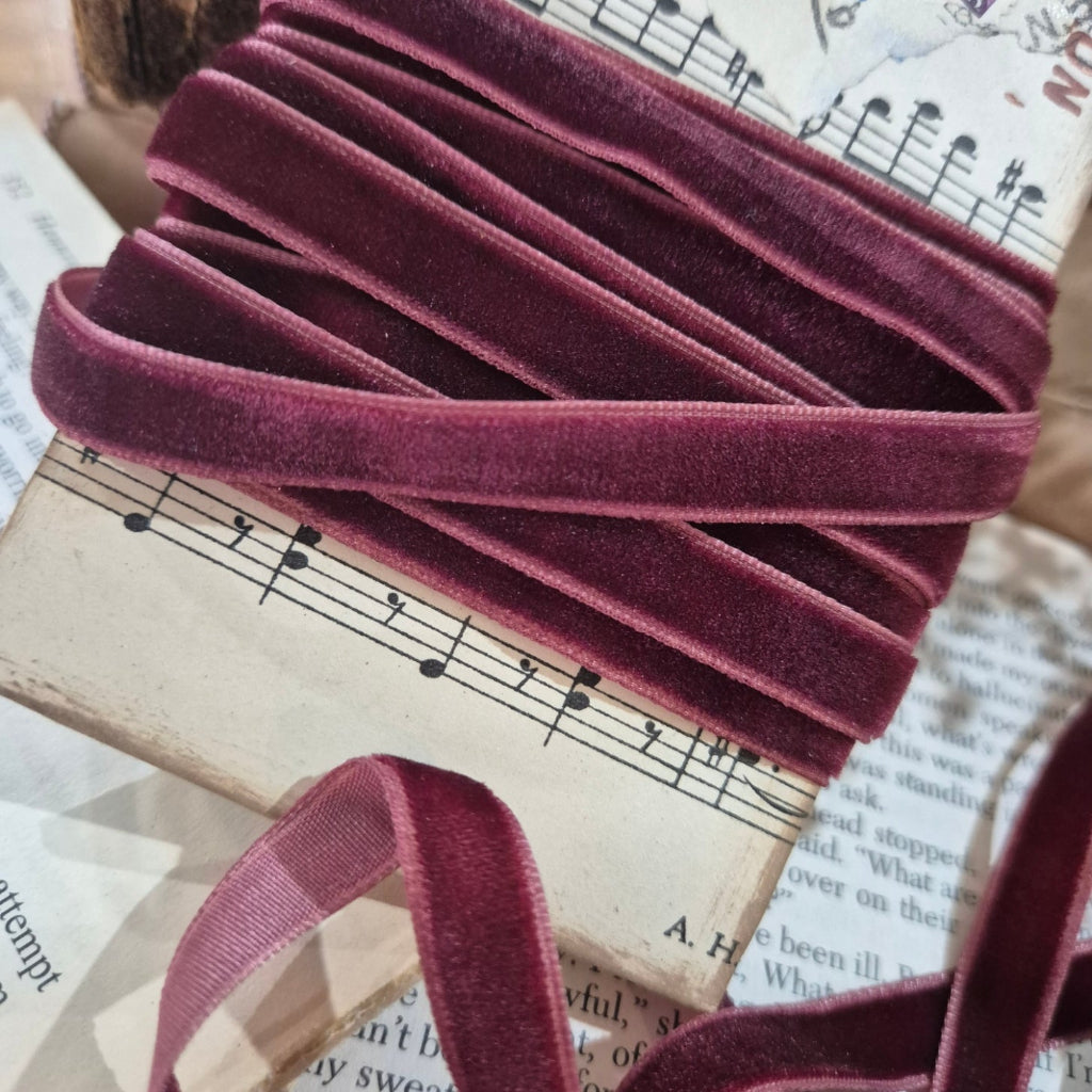 Maroon velvet ribbon on an old book with music notes