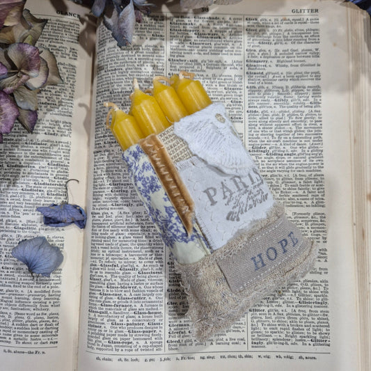 Book with a decorative item on top featuring text and yellow candles.