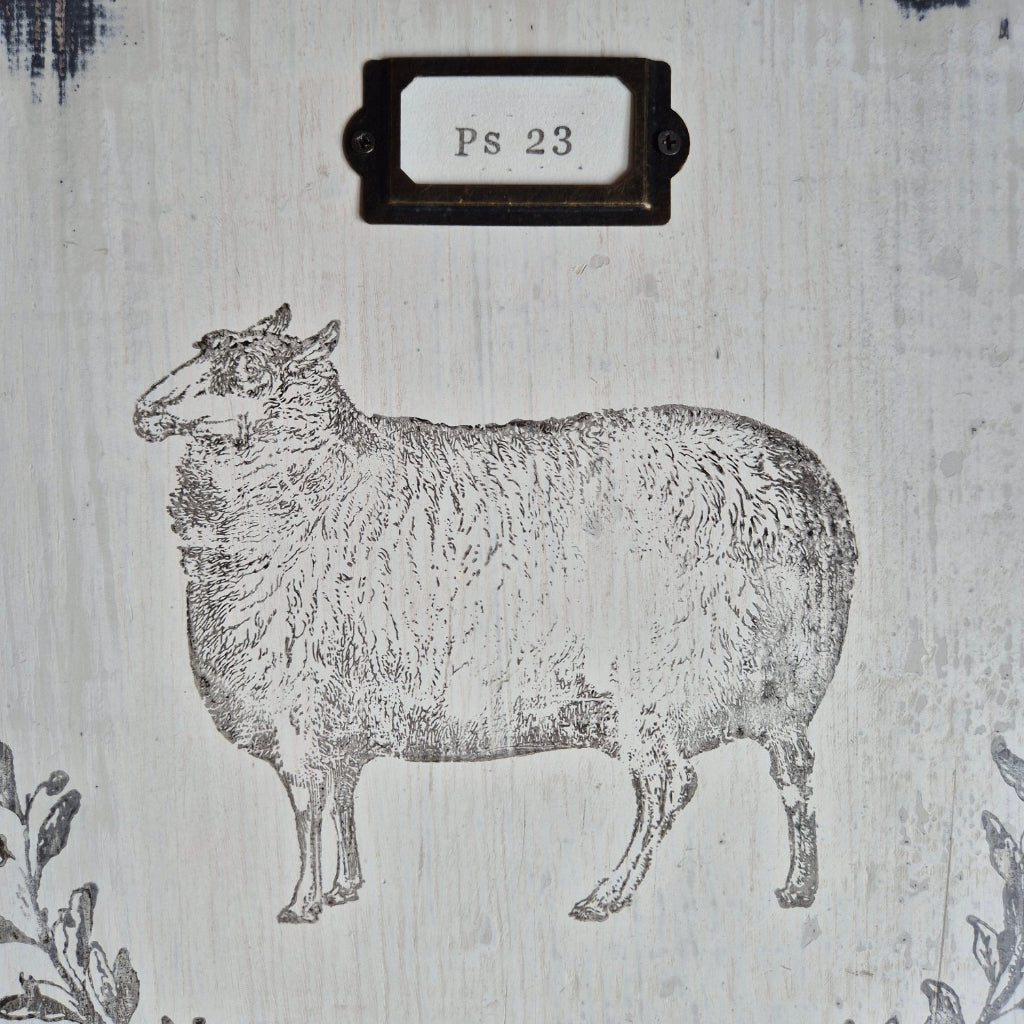 Black and white illustration of a sheep on textured paper with a label reading 'Ps 23'.