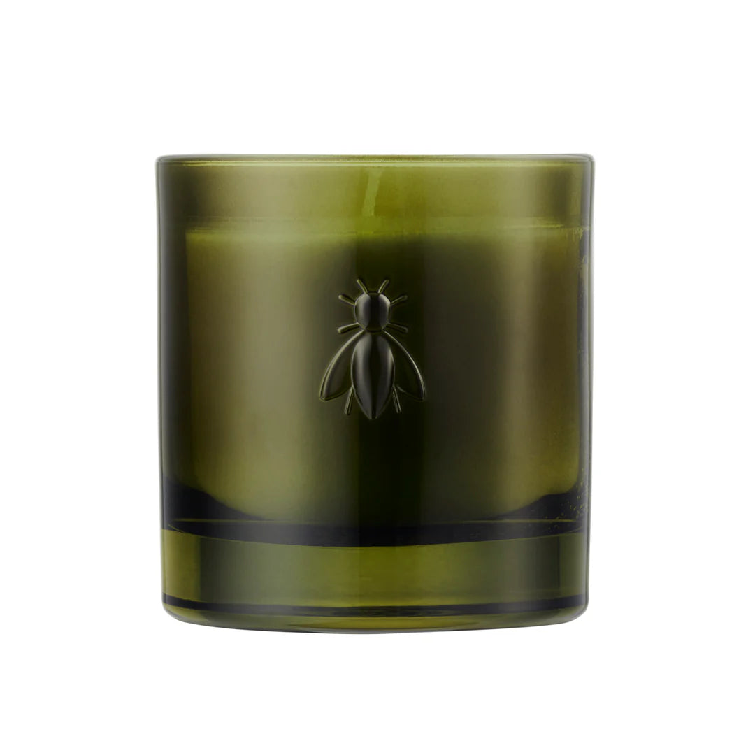Green candle with a bee design on a white background
