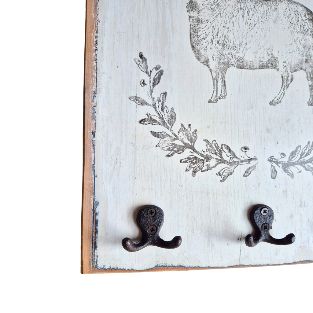 Decorative wall hook with sheep and floral design on a wooden board