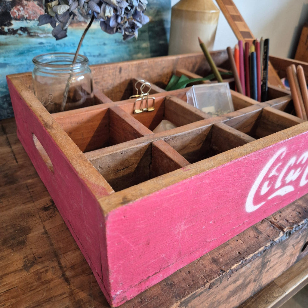 Wooden desk organizer with Coca-Cola branding on a cluttered desk.