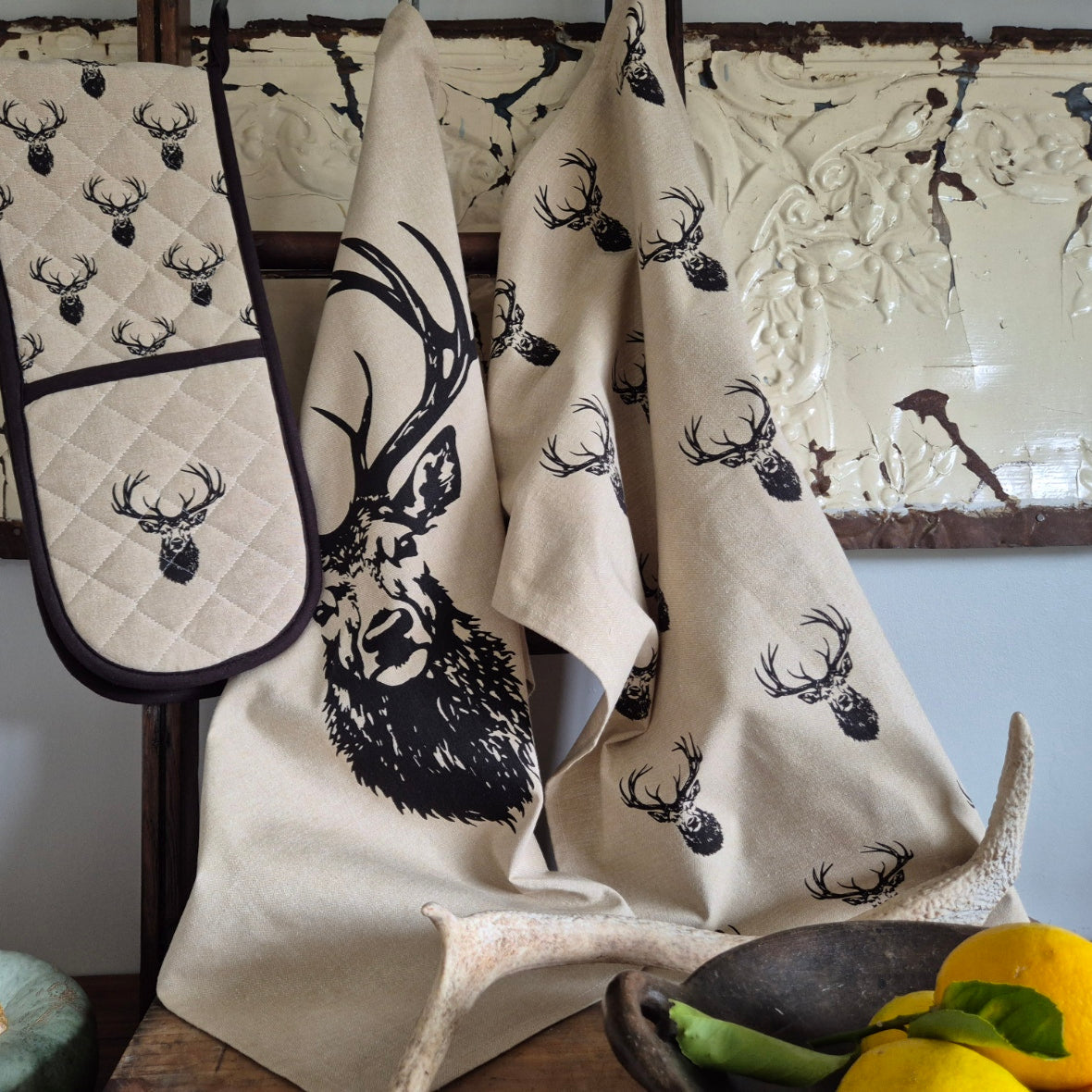Set of kitchen towels and oven mitts with deer head design.