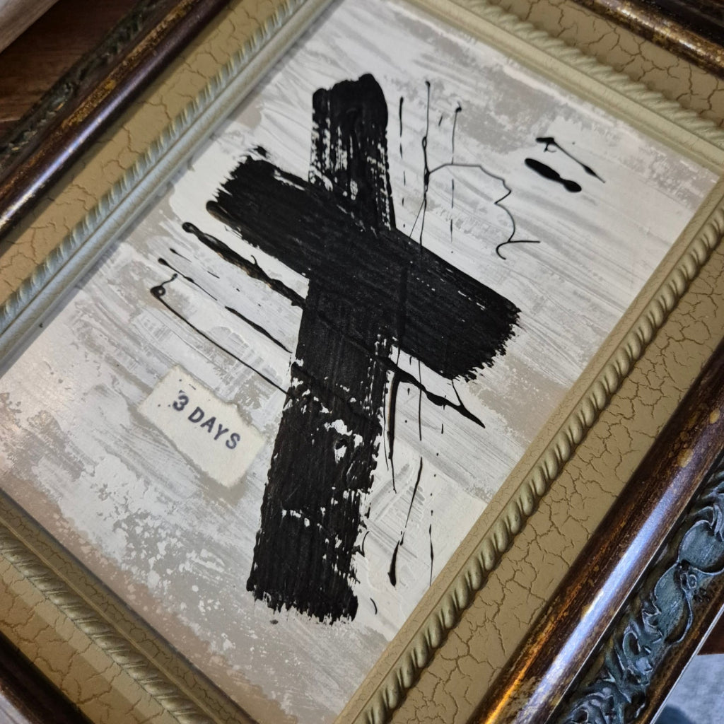 Framed abstract artwork with black brush strokes on a textured background