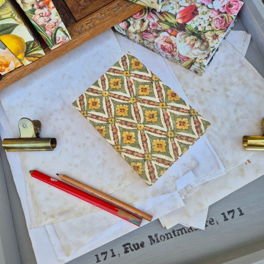 Patterned fabric, pencils, and stationery items on a textured surface