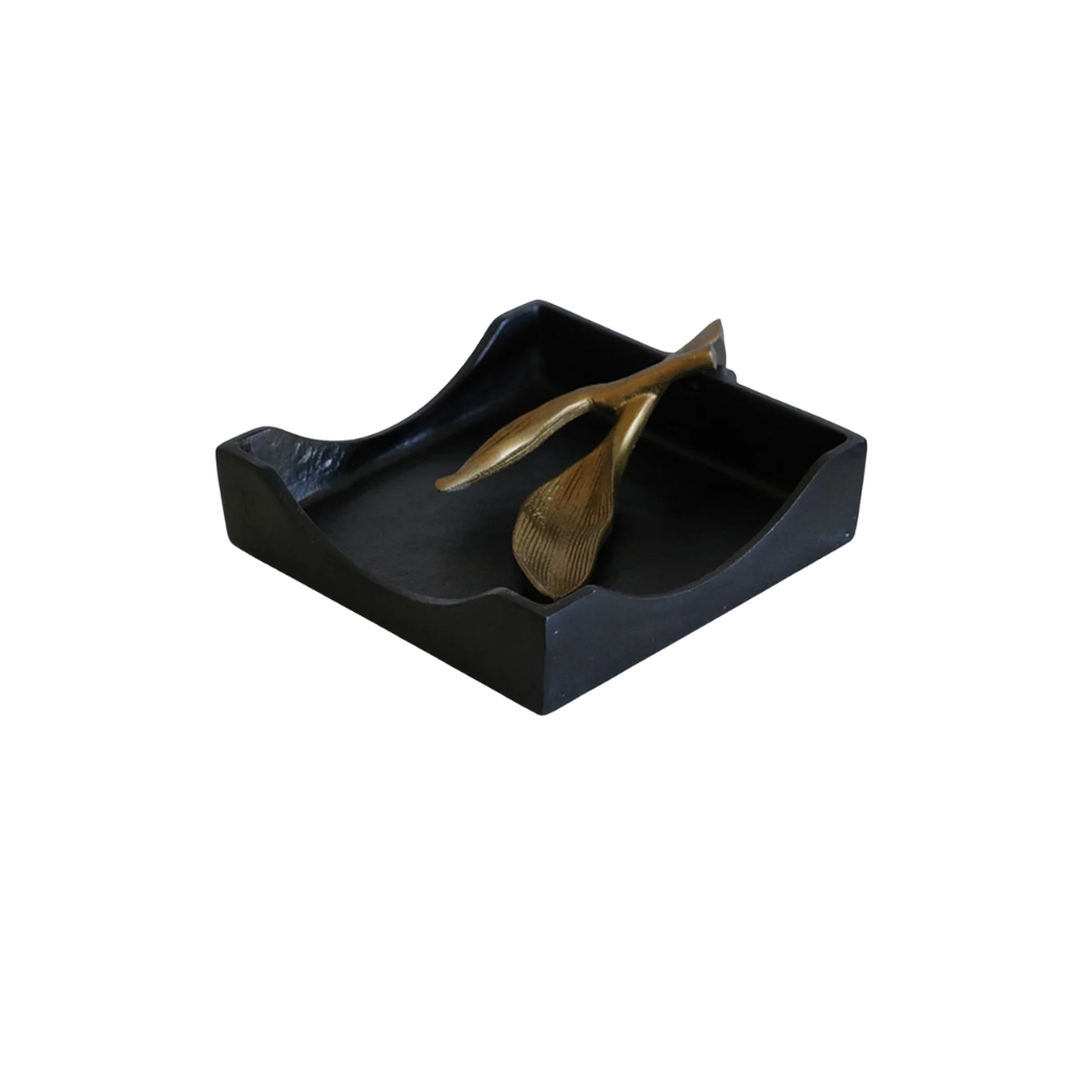 Black rectangular napkin with a gold leaf holder on a white background