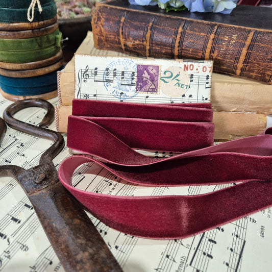 Maroon belt on a surface with vintage books and sheet music