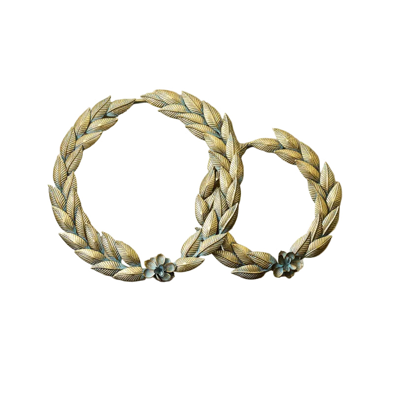 Two gold leaf wreaths with floral accents on a white background