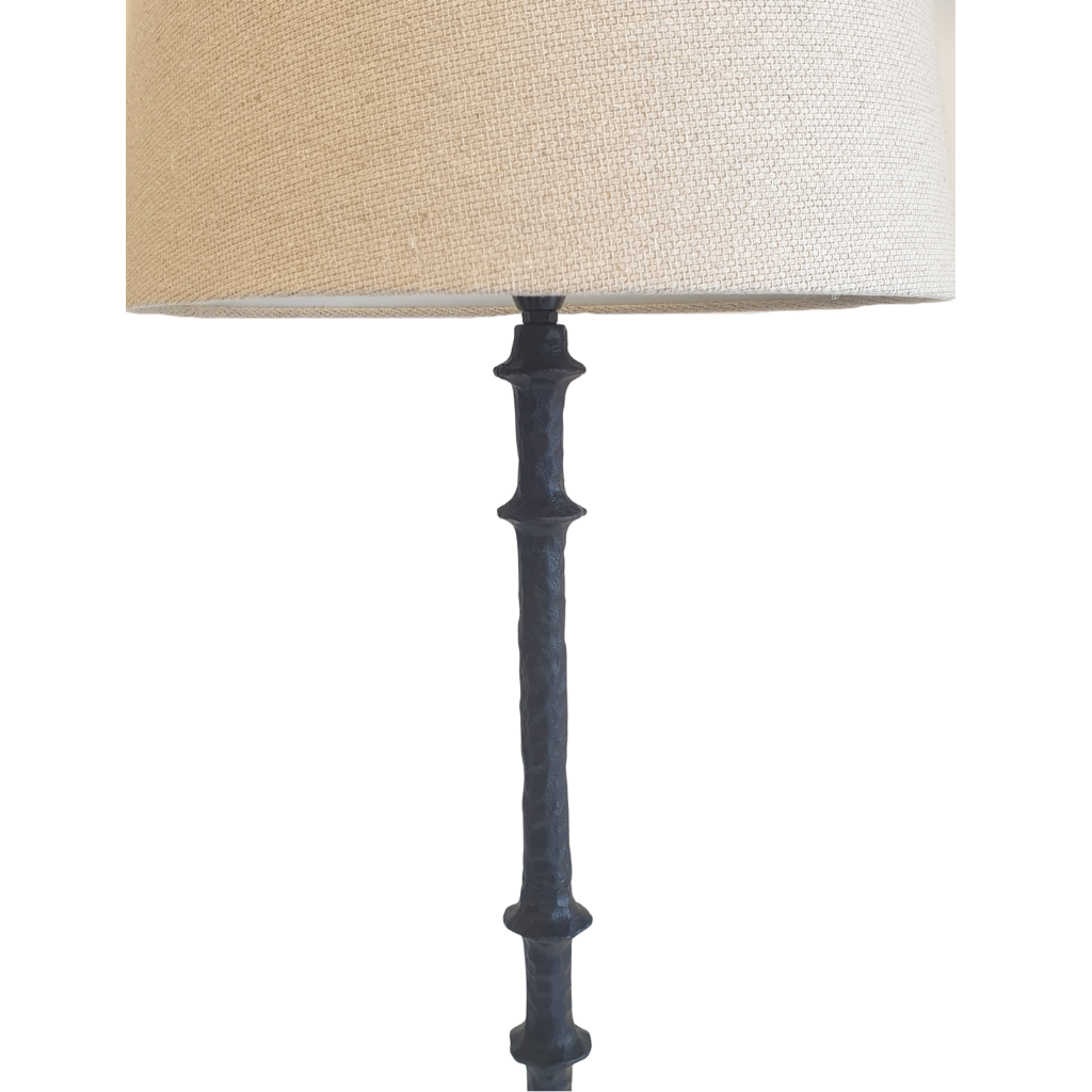 Lamp with a beige shade and black metal base on a white background