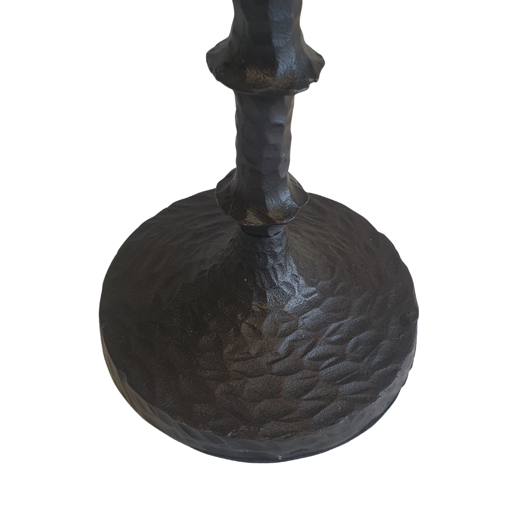 Black metal candle holder with textured base on a white background