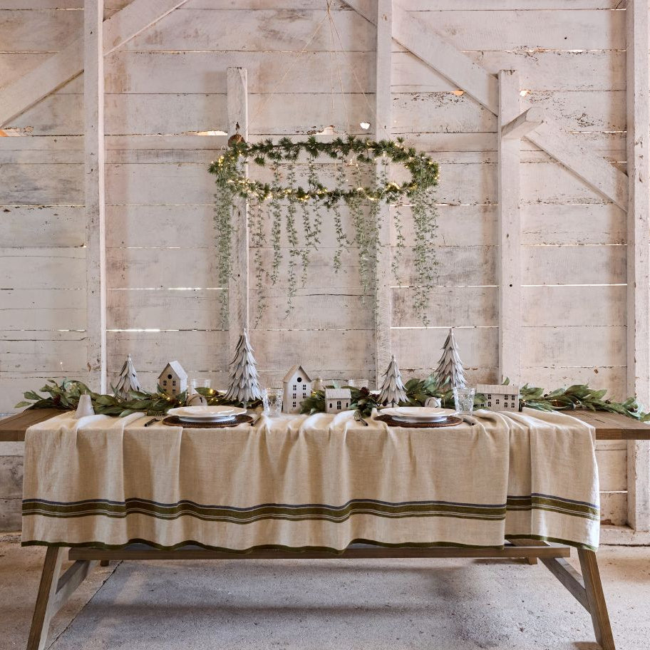 French Country Dining table set with a striped tablecloth in a rustic room