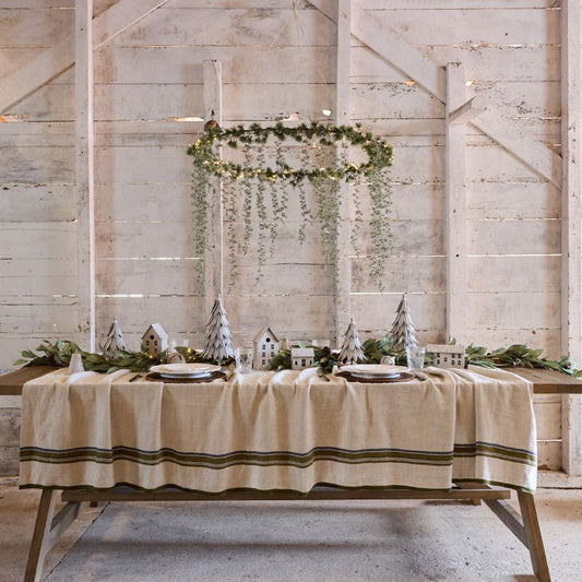 French Country Dining table set with a striped tablecloth in a rustic room
