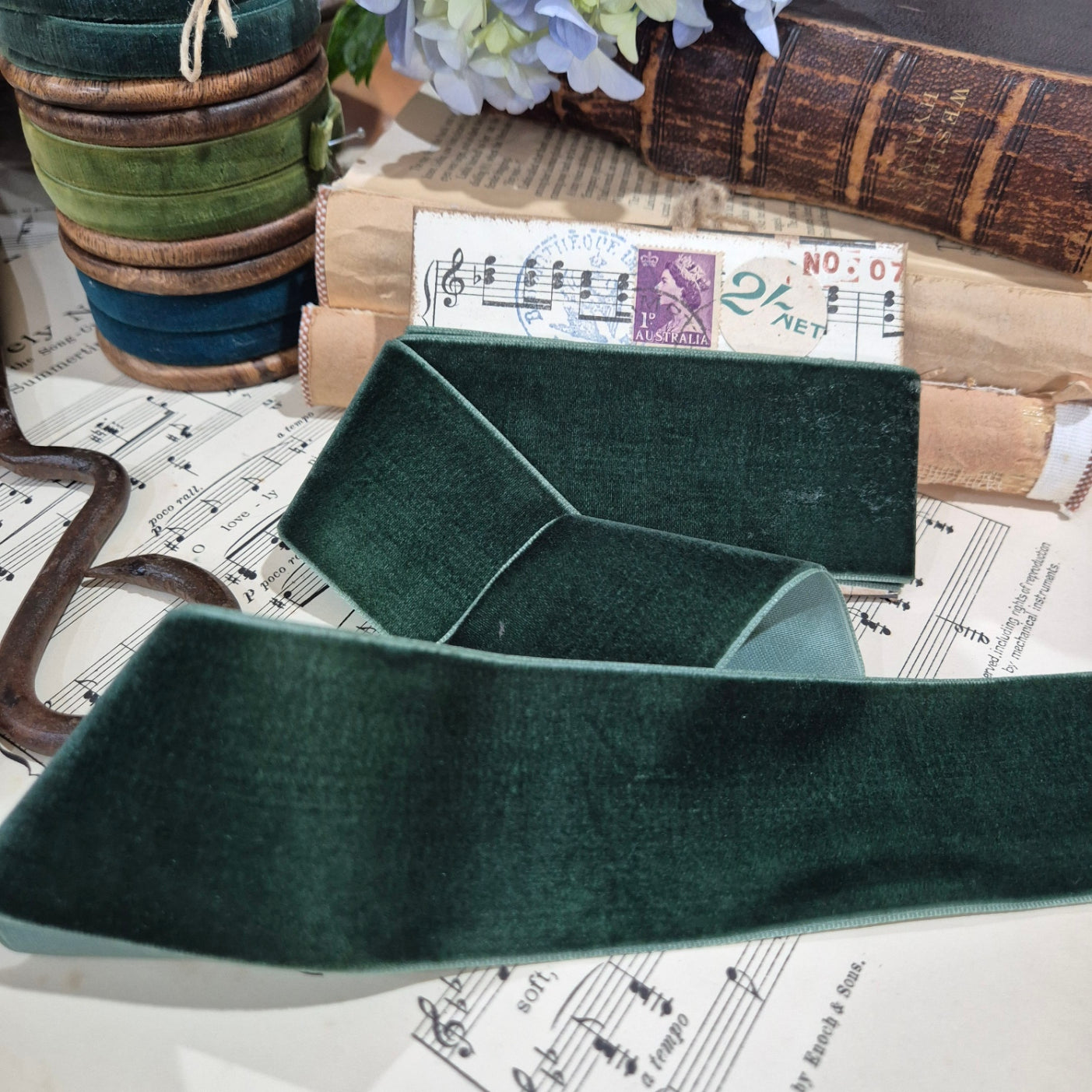 Green velvet ribbon on a surface with music sheet background