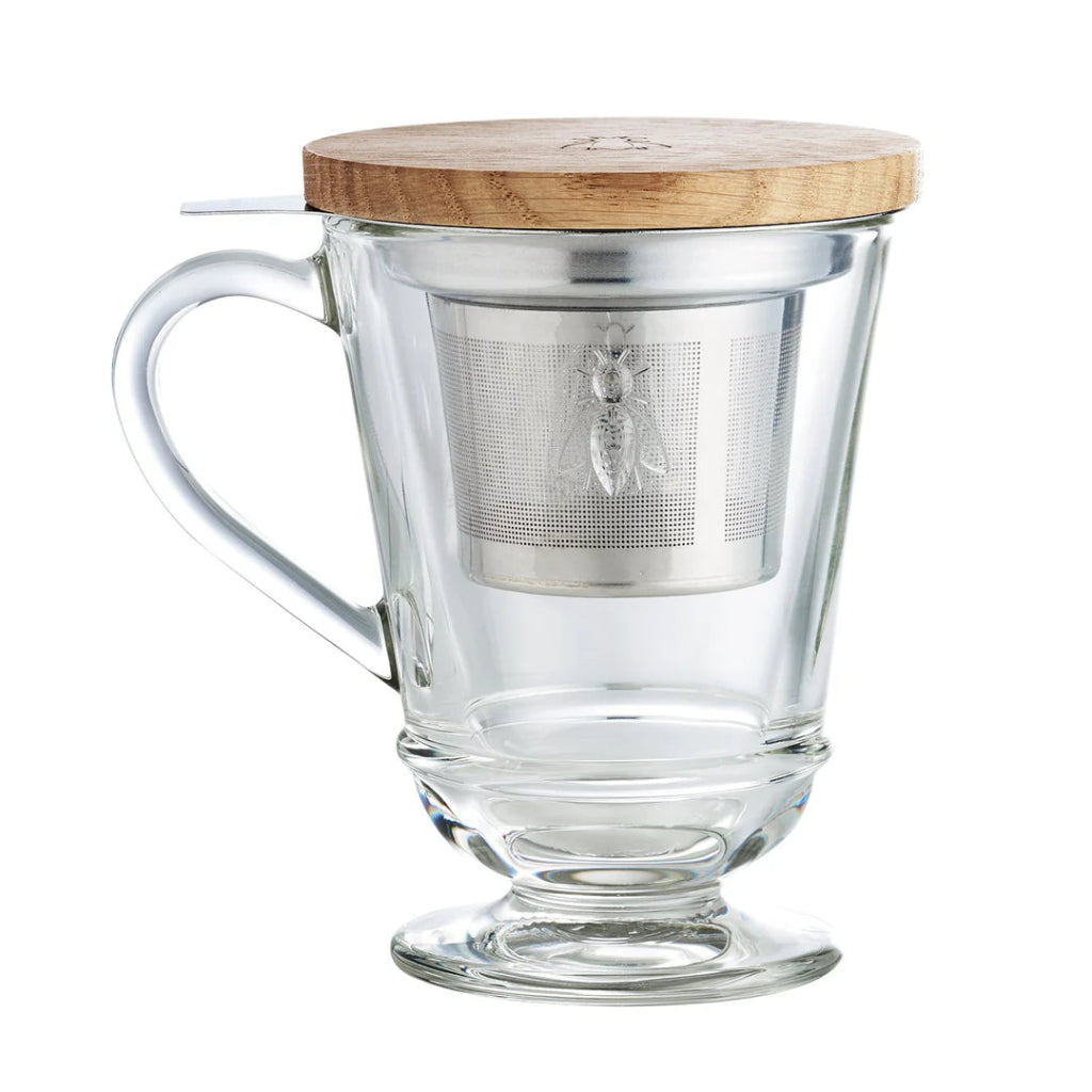 Clear glass mug with wooden lid and metal tea infuser on a white background