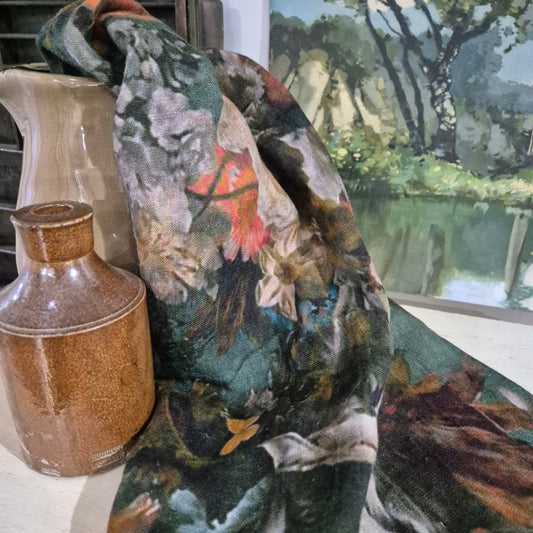 Floral-patterned fabric draped over a jug with a painting in the background