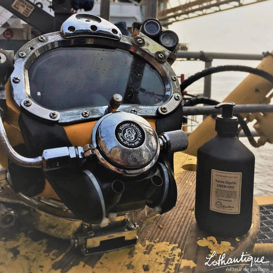 Scuba diving regulator with a bottle of Lothantique perfume on a wooden surface