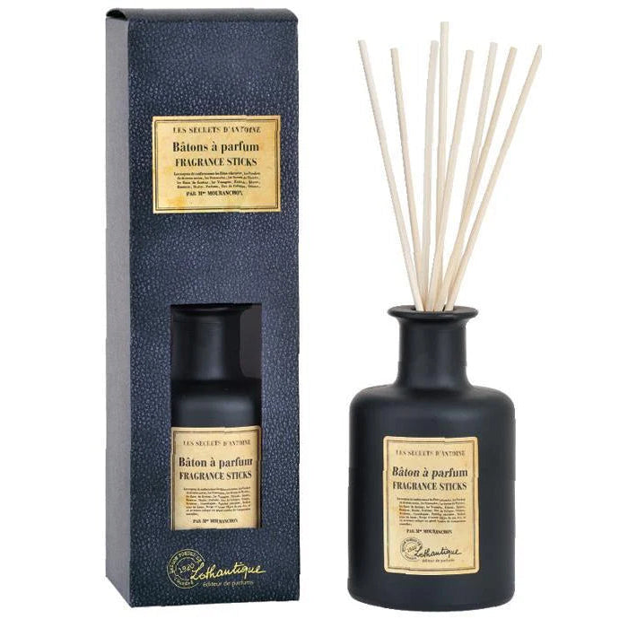 Black diffuser bottle with fragrance sticks and packaging on a white background