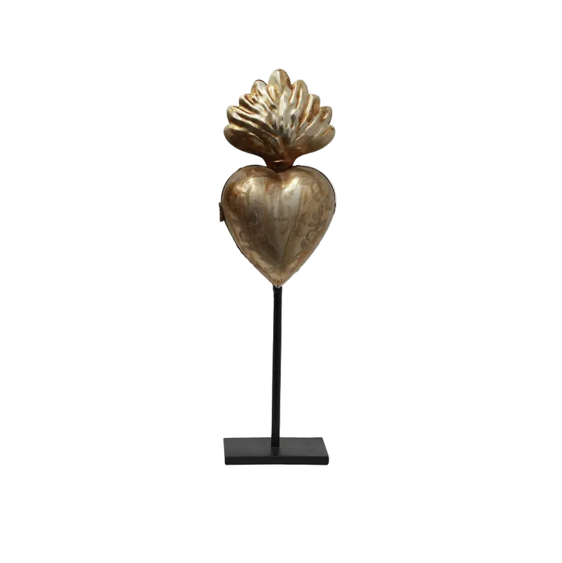 Decorative sculpture of a heart with a shell on a stand against a white background