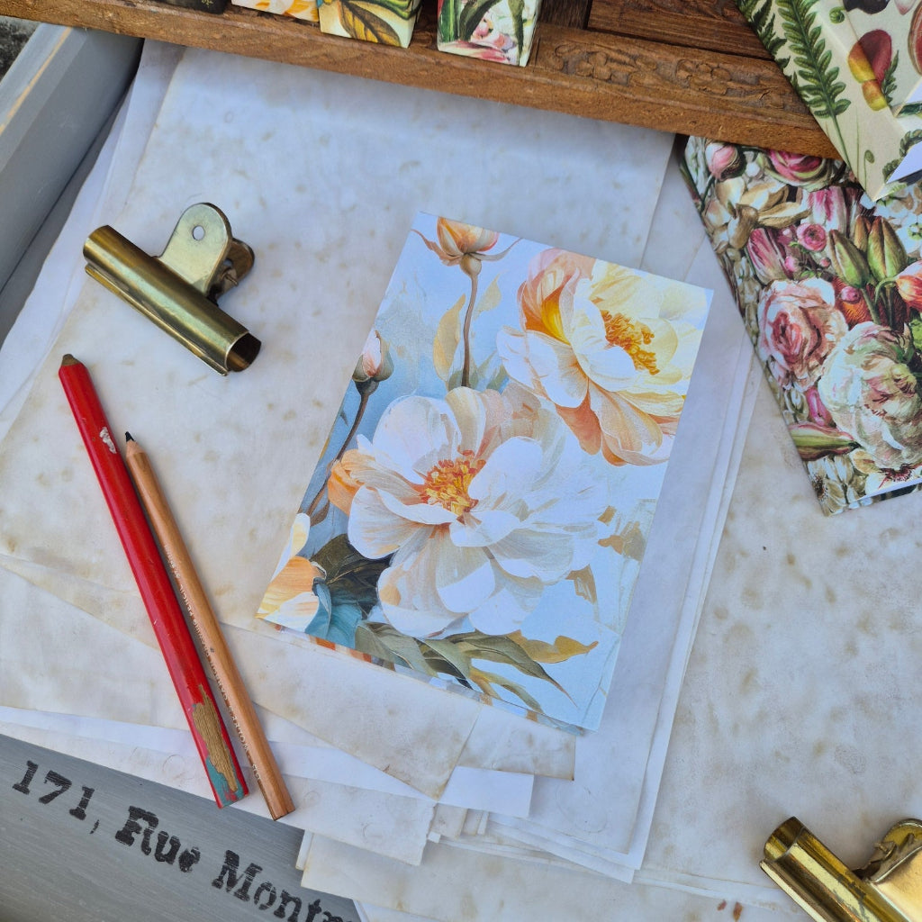 Floral note book on a textured surface with stationery items