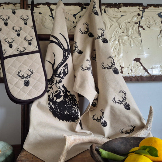 Set of kitchen towels and oven mitts with deer head design.