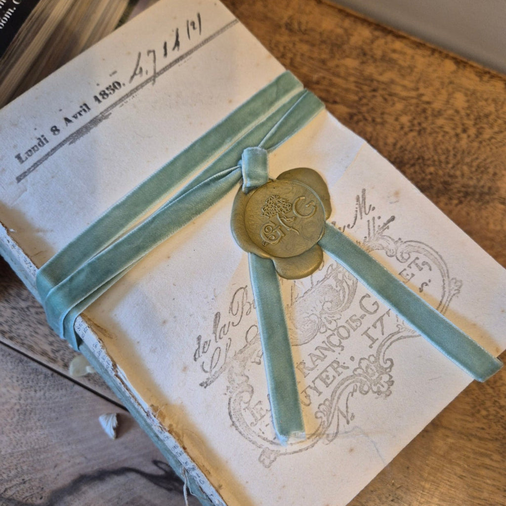 Vintage book with decorative ribbon and seal on a wooden surface