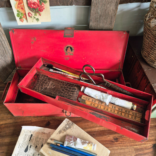 Red vintage tool box with tools on a wooden surface