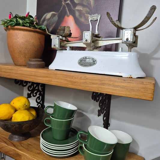 Vintage kitchen scale with green cups and lemons on a wooden surface