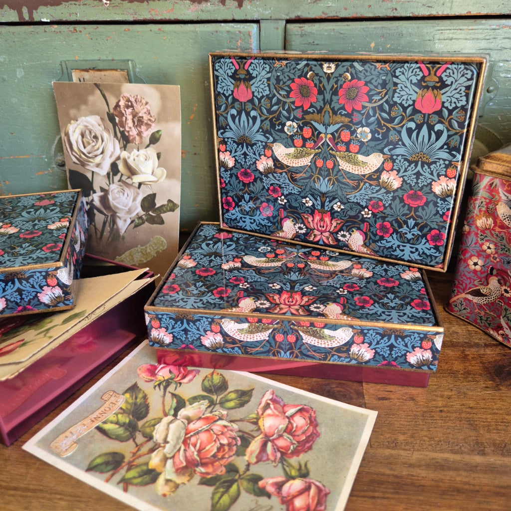 Floral patterned  postcards in a William Morris Tin on a wooden surface